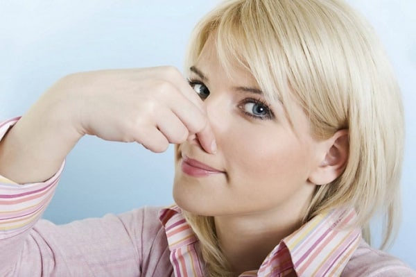 woman holding her nose