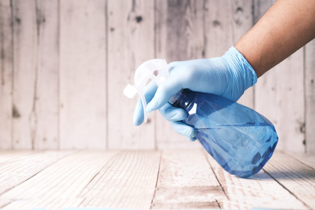 A person holding a commercial cleaning bottle of cleanser.