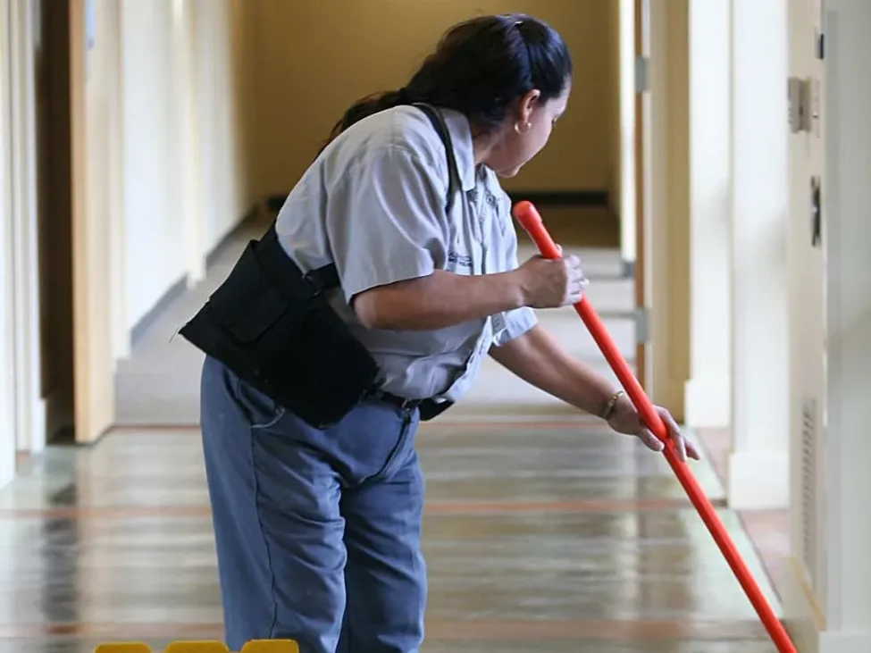 Commercial janitorial staff mopping hallway floor during routine cleaning service in Charlotte NC